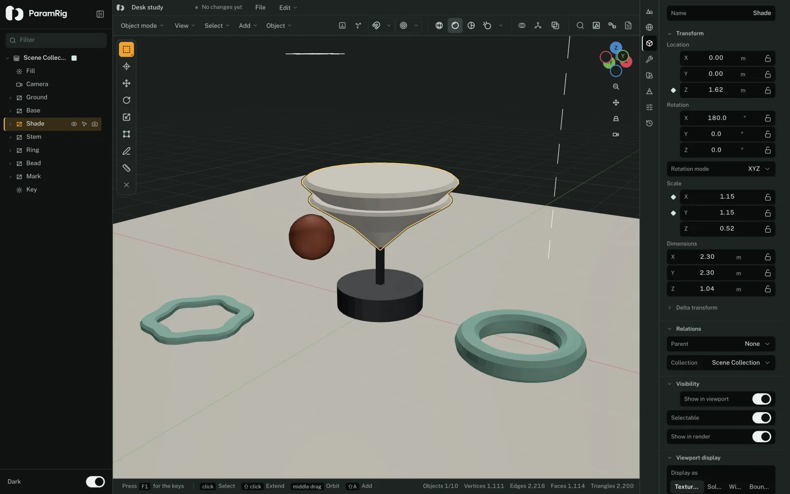The ParamRig 3D editor with a desk study open: an outliner naming ten objects, a lamp built from a base, a stem and an inverted cone shade, a ring and a bead on the ground, and a status bar counting 1,111 vertices
